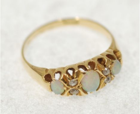 EDWARDIAN OPAL AND DIAMOND SET RING, set with three graduated oval opals and four old cut diamonds, 18ct gold band, size J ½,