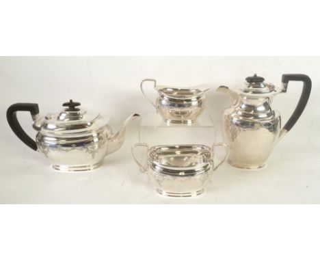 GEORGE V FOUR PIECE ENGRAVED SILVER TEA SET, of rounded oblong form with black angular scroll handles and knops and moulded r