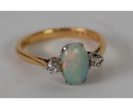 18ct GOLD AND PLATINUM RING, set with a cabochon oval opal and two small side diamonds, 2.9gms, approx .08ct in total 