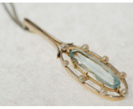 EDWARDIAN AQUAMARINE AND SEED PEARL SET GOLD OPENWORK PENDANT; with central oval cut aquamarine with oval frame set with eigh