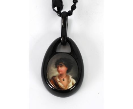 A LATE VICTORIAN FACETED JET NECKLACE, suspending a jet framed ceramic cameo enamelled with a female bust 