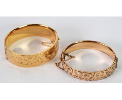 A ROLLED GOLD BROAD OPENING HOLLOW BANGLE, with foliate  scroll engraved top and a SIMILAR BUT NARROWER ROLLED GOLD HINGE OPE