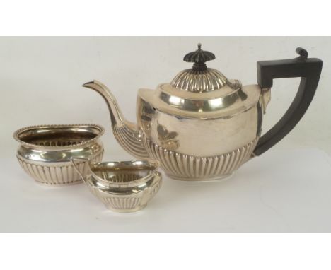 COMPOSITE SILVER BACHELOR THREE PIECE TEA SERVICE, each of oval demi gadrooned form, the  TEAPOT with blackwood handle and kn