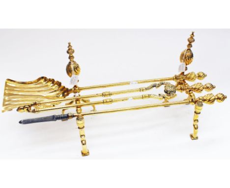 A late Victorian brass companion set, including andirons and three fire tools, each with wrythen fluted knops (5) 