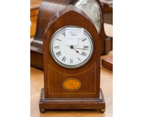An Edwardian mahogany mantle clock of Gothic form, with a white enamelled dial and black Roman numerals 