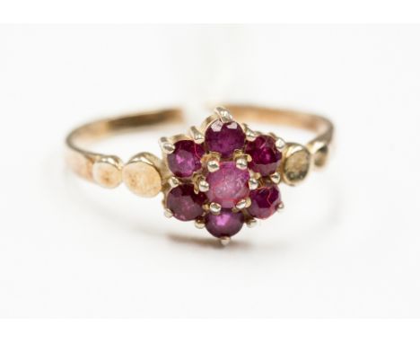 A ruby cluster ring set in yellow metal, possibly 18ct untested 