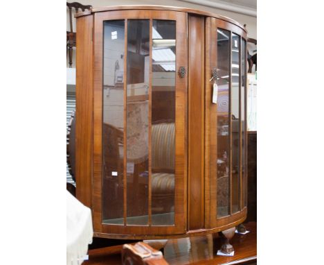 An Art Deco walnut veneered display cabinet, of bow fronted form