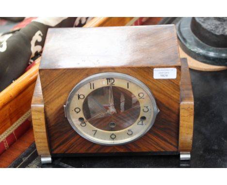 An Art Deco figured walnut veneer mantle clock, the 6.5 inch dial with silvered chapter ring within a chrome bezel, on chrome