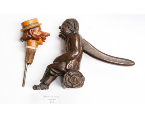 A Black Forest novelty carved nut cracker, seated lady, holding a hob nut, with a novelty wine dispenser 