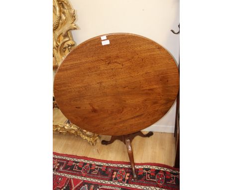 A George III mahogany tilt tip tripod table, the circular top made from one piece of mahogany raised on a turned column and s