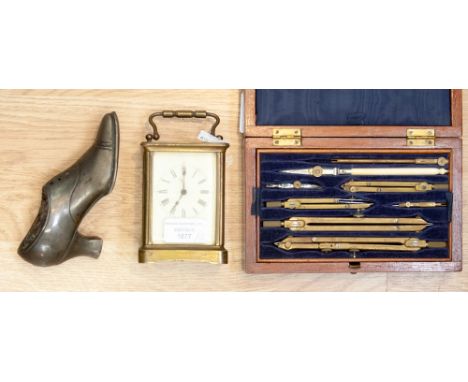 A French Parisian gilt brass carriage clock; together with an architects kit and a pin cushion modelled with a spelter shoe 