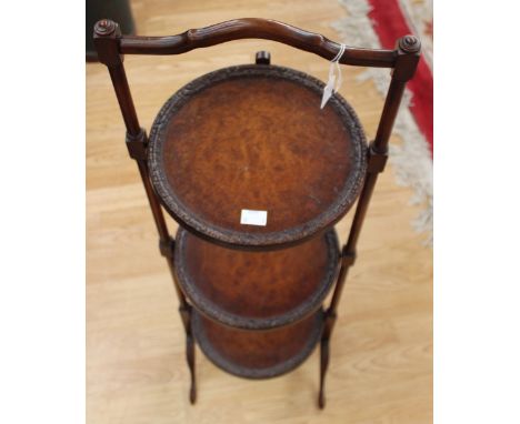 An early 20th Century walnut veneered three tier folding cake stand; together with a small tripod wine table, cake stand meas