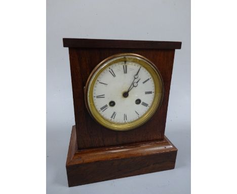 A VICTORIAN ROSEWOOD CASED MANTEL CLOCK, of rectangular form on plinth, circular white enamel dial with Roman numerals inscri