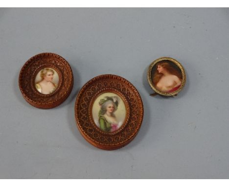 THREE OVAL PORCELAIN PORTRAIT MINIATURES, lady in green dress with feathered hat set in carved roundel border frame inscribed