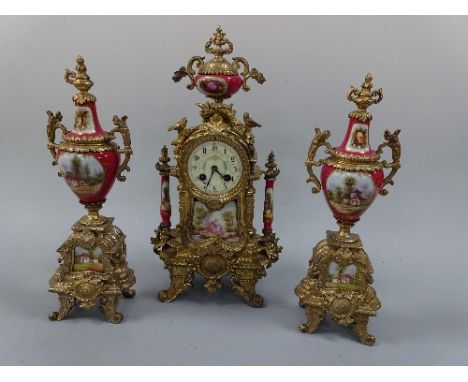 A CLOCK GARNITURE, the gilt metal clock having ceramic panel depicting courting couple under circular dial with Arabic numera