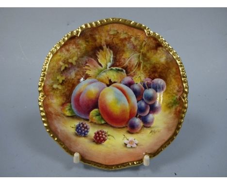 A ROYAL WORCESTER PLATE, with hand painted peaches and grape decoration to mossy bank, shaped gilt border, signed D Fuller, b