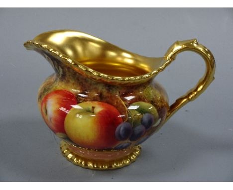 A ROYAL WORCESTER MILK JUG, having hand painted apples, grapes and blackberries to mossy bank, with gilt loop handle and shap
