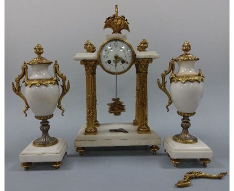 A CLOCK GARNITURE, the circular white enamel dial having floral swag and Arabic numerals detail supported on four gilt column