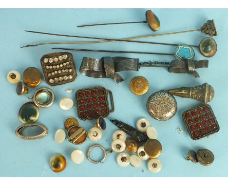 A large engraved white metal cloak pin in the form of two bows, two hat pins set opercula and other hat pins, buttons, buckle