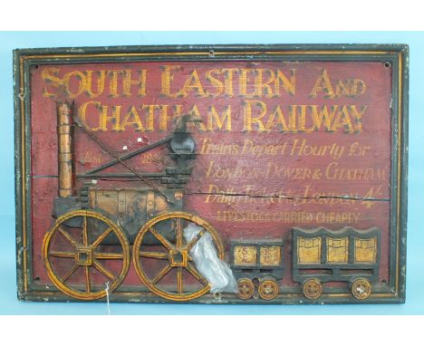 A 20th century South Eastern and Chatham Railway painted advertising board applied with a model of an early steam engine and 