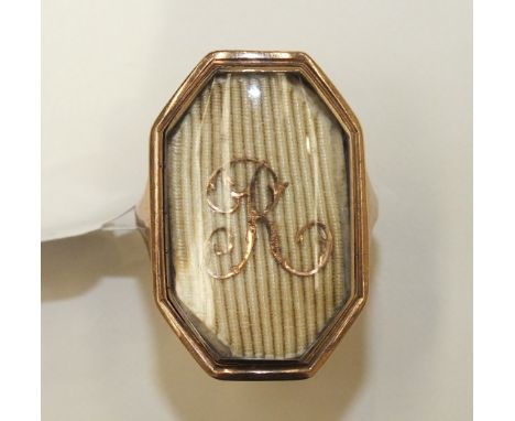 An early 19th century mourning ring of long octagonal shape, the glazed panel with the initial R, on unmarked gold mount, siz