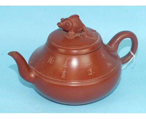 A 20th century Chinese Yxing stoneware teapot and cover with incised script decoration, the cover with fish finial, 19cm over