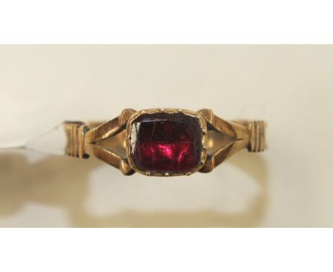 An early-19th century gold ring set foiled garnet, size K, 1g.