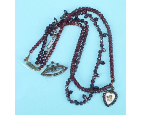 A small heart-shaped pendant with ceramic plaque depicting a cherub, within a border of garnets on faceted garnet bead neckla