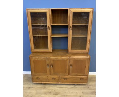 Ercol display cabinet with a pair of glazed doors over three cupboards and two drawers, 130 x 43 x 169cms. Estimate £100-150.