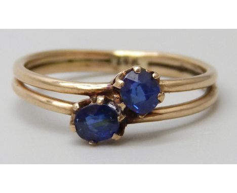 A 14k gold two stone sapphire crossover ring, 1.7g, K