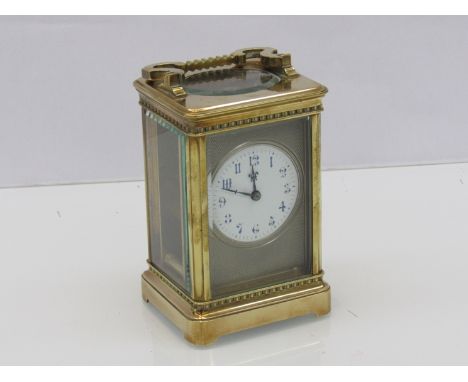 An early 20th Century French brass carriage timepiece with Arabic enamelled dial surrounded by an engine turned mount, with k