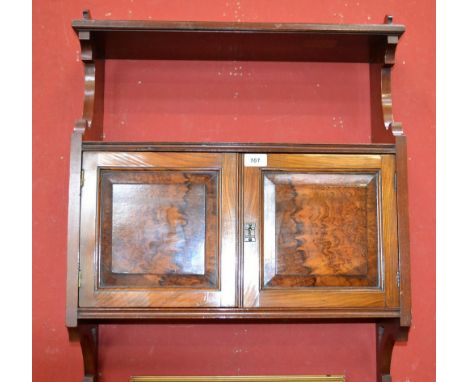 An Edwardian wall mounted cupboard, galleried shelf over figured walnut fielded panel doors