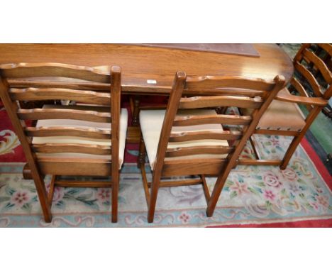 A large oak trestle table, rounded ends, carved cup and cover supports, two ladder back carvers; four ladder back dining chai