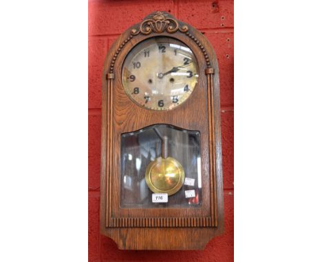 An early 20th century oak wall clock, arched case, pendulum
