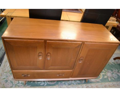 An Ercol Windsor sideboard, two door cupboard over long drawer, advacont larger cupboard, spreading legs, H-frame stretchers