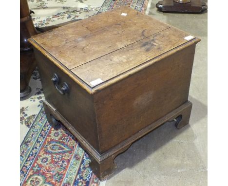 An oak rectangular lidded box with metal carrying handles, raised on bracket feet, 54cm wide, 47cm high.