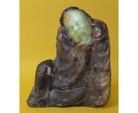 A Chinese stone figure with carved jade face and hand, 12.5cm high.