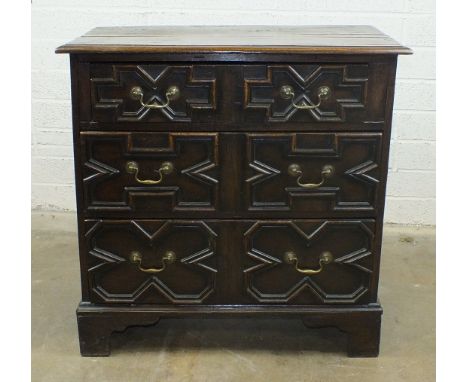 An antique oak chest of three drawers applied with mouldings, on bracket feet, 82cm wide, 82cm high.