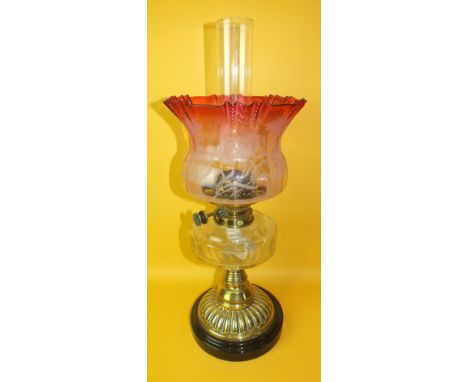 A late-Victorian oil lamp, the faceted clear glass reservoir fitted with Hinks & Son burner, on short brass column and fluted