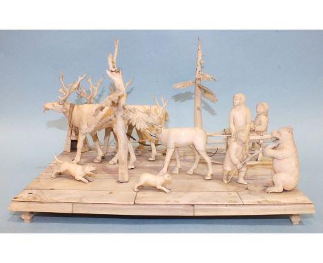 An interesting 19th century carved marine ivory diorama group, comprising an Eskimo family on sled pulled by reindeer, trees,