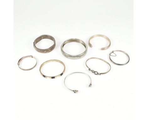 An assorted collection of silver bangle bracelets. The lot to include a rams head torque bangle, hallmarked for London 1984, 