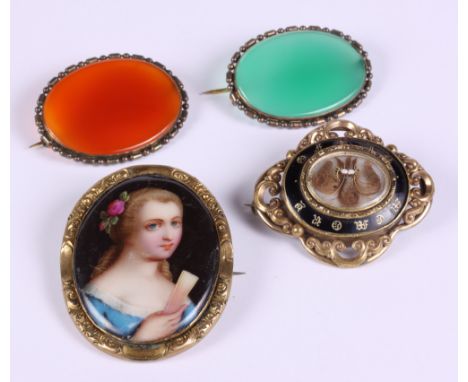 A gilt metal and enamel mourning brooch, a gilt metal mounted porcelain miniature and two hardstone brooches