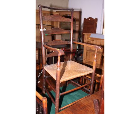 A rush seat ladder back armchair and a matching standard chair