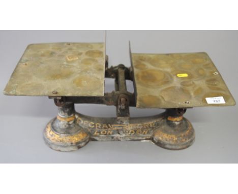 A set of Degrave & Short balance scales with brass platforms and a black cast iron set of scales with six weights