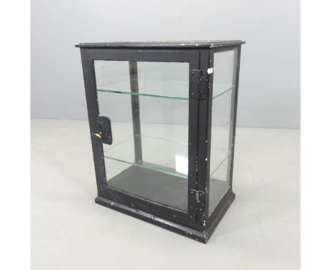 A vintage painted metal medicine cabinet, with glazed panelled door and sides and two glass shelves. 48x62x33cm.Lacking key, 