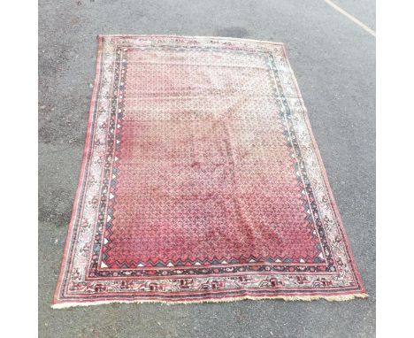 A red-ground Persian carpet. 320x235cm.