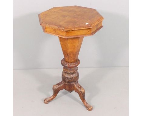 A Victorian walnut octagonal sewing table, with lifting lid, tripod base and carved decoration. 15x79cm. 