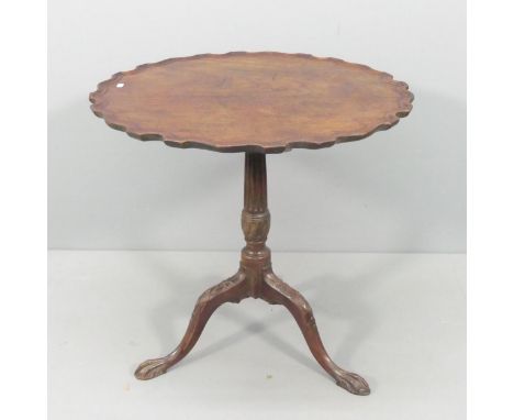 An antique mahogany tilt-top occasional table, with piecrust edge and tripod base with carved and fluted decoration. 69x68cm 