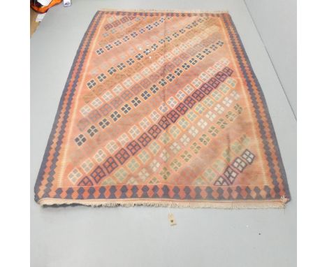 A red-ground Kilim carpet. 244x165cmFaded, but otherwise good condition. 