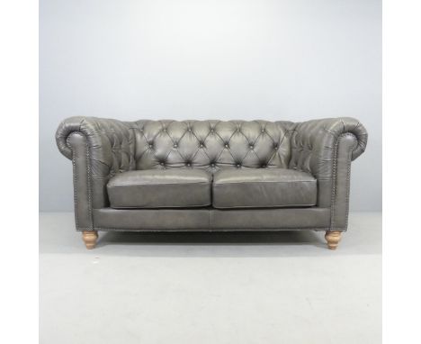 A modern Chesterfield style button-back leather upholstered lounge suite, comprising a two-seater sofa and matching armchair.